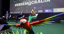#PraTodosVerem: Na fotografia, o palco de um evento, com três pessoas sentadas em poltronas, em ...