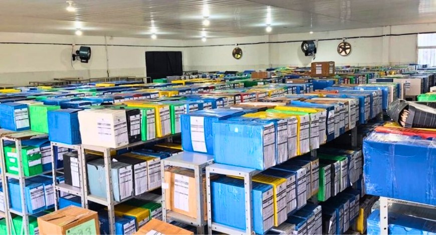 #PraTodosVerem: Na fotografia aparece uma sala ampla repleta de caixas de arquivos organizadas e...