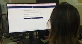 #PraTodosVerem: Na fotografia aparece uma mulher de costas, observando um monitor de computador ...
