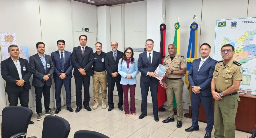 #PraTodosVerem: Na fotografia aparece um grupo de pessoas em pé e posando para a foto tendo ao c...