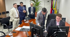 #PraTodosVerem: Na fotografia aparece um homem de terno escuro e gravata rosa sentado diante de ...