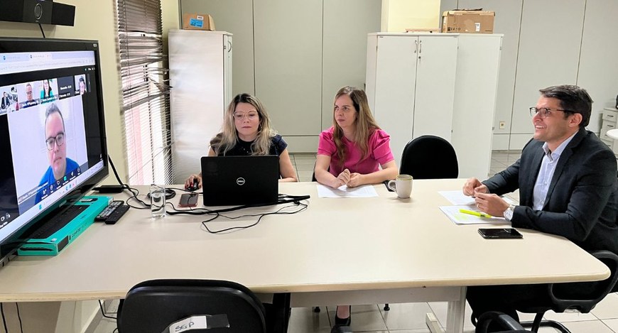 #PraTodosVerem: Na fotografia aparece três pessoas sentadas, em uma sala de reunião on-line, sob...