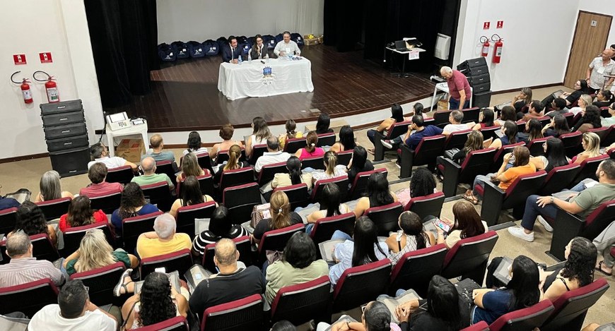 #PraTodosVerem: Na fotografia aparecem três pessoas no palco de um teatro, falando para um públi...