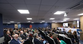Capa#PraTodosVerem: Na fotografia, aparece uma mesa com palestrantes que está posicionada diante...