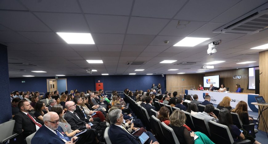 Capa#PraTodosVerem: Na fotografia, aparece uma mesa com palestrantes que está posicionada diante...