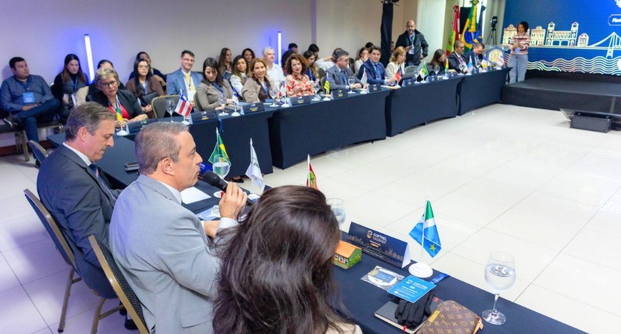 #PraTodosVerem: A fotografia mostra uma reunião institucional realizada em um auditório. Em form...