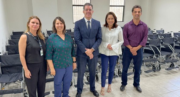 #PraTodosVerem: Na fotografia aparece um grupo de cinco pessoas em pé em frente a 50 cadeiras de...