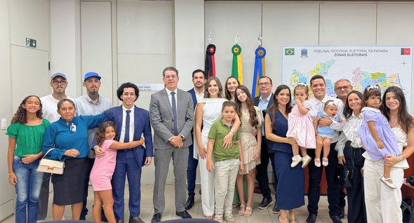 Analistas judiciários aprovados em concurso tomam posse no TRE-PB PraTodosVerem: Na fotografia aparecem os empossados com seus familiares e o presidente do TRE-PB