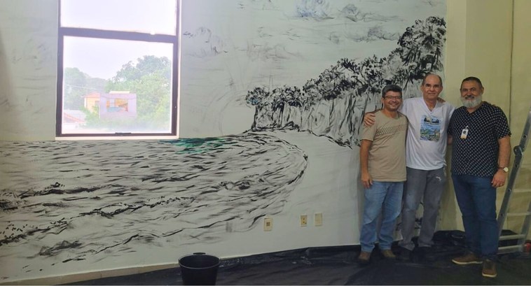 Arte e poesia vão colorir os corredores do TRE-PB #PraTodosVerem: Na fotografia aparecem três homens em pé, ao lado de um mural artístico que repr...