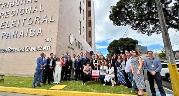 #PraTodosVerem: Na fotografia aparece um grupo de pessoas em torno do Banco vermelho instalado n...