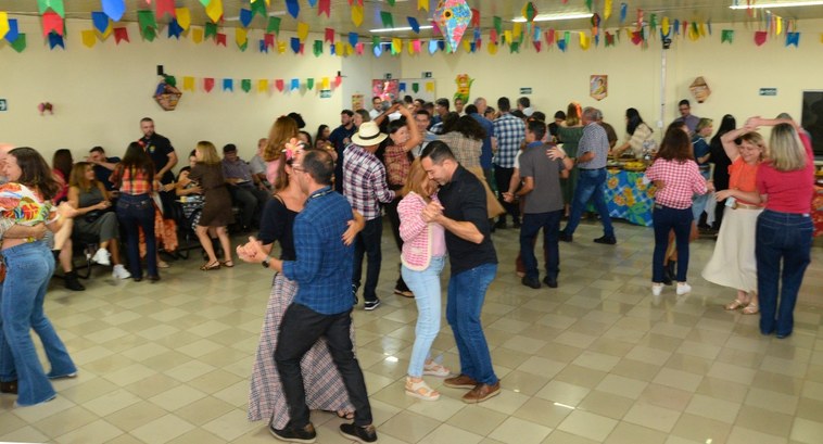 Comemoração junina integra servidores da sede da justiça eleitoral #PraTodosVerem: Na fotografia aparecem pessoas dançando e confraternizando no evento.