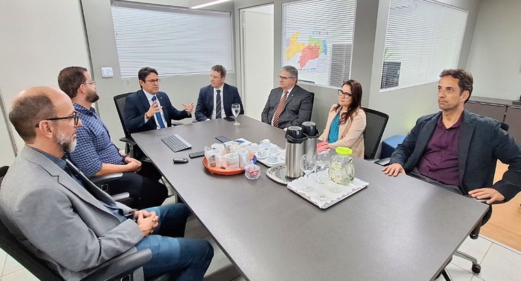 #PraTodosVerem: Na fotografia aparece um grupo de pessoas reunidas em torno de uma mesa tendo na...