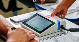 #pratodosverem: na fotografia aparecem uma urna eletrônica ao centro e as mãos de um mesário e d...
