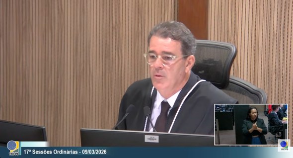 #PraTodosVerem: Na fotografia aparece um home vestindo toga falando em um microfone.