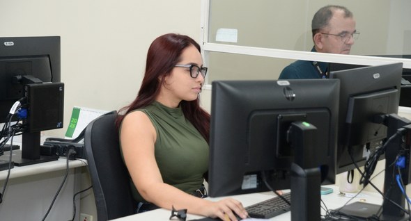 #PraTodosVerem: Na fotografia aparece uma mulher, sentada em um cadeira, trabalhando em um compu...