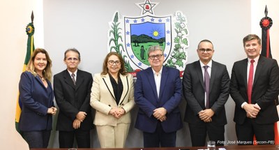 #PraTodosVerem: Na fotografia aparecem pessoas em pé; ao fundo, à esquerda,  aparece uma bandeir...