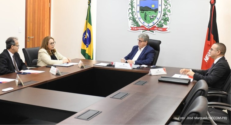 Eleições 2024 é tema do encontro entre TRE-PB e Governo da Paraíba_3 #PraTodosVerem: Na fotografia aparecem pessoas sentadas em cadeiras, em volta de uma mesa retang...