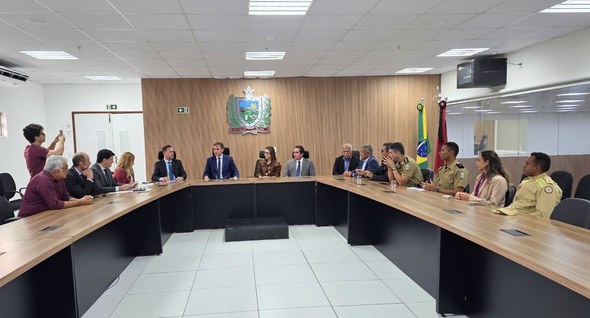 #PraTodosVerem: Na fotografia aparece um grupo de pessoas sentadas em torno de uma mesa em forma...