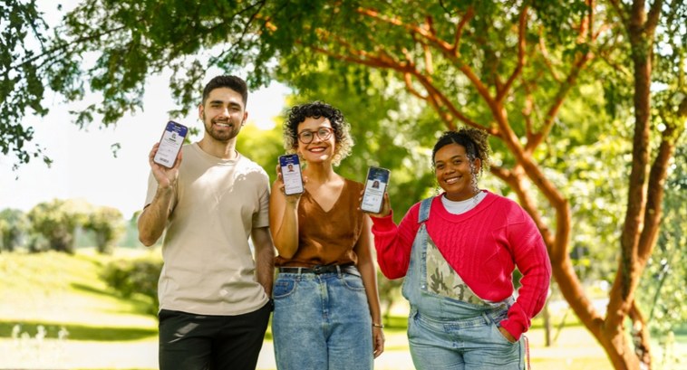 Eleitor em Dia: conheça vantagens e serviços oferecidos pelo aplicativo e-Título #PraTodosVerem: Na fotografia aparecem três pessoas, um homem e duas mulheres, exibindo um smart...