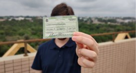 #PraTodosVerem: Na fotografia aparece um homem segurando um título eleitoral na altura do rosto....