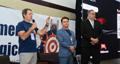 #PraTodosVerem: #PraTodosVerem: Na fotografia aparecem três homens ladeados, um deles fala em um...