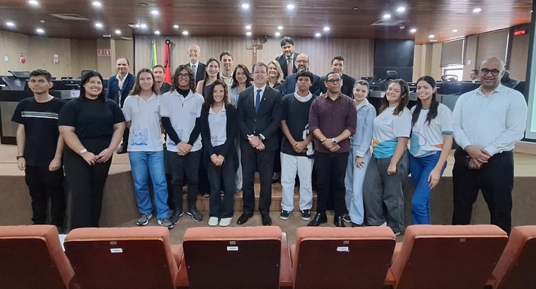 Estagiários do programa Primeira Chance tomam posse no TRE-PB #PraTodosVerem: Na fotografia aparece um grupo de pessoas posando para foto no plenário do TRE-PB.