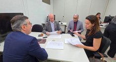 #PraTodosVerem: Na fotografia aparecem quatro pessoas reunidas em torno de uma mesa analisando p...