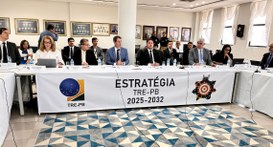 #PraTodosVerem: Na fotografia homens e mulheres sentados em uma mesa, que tem o nome Estratégia,...