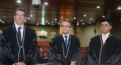 #PraTodosVerem: Na fotografia aparecem três homens em pé, vestindo becas, na solenidade de posse...