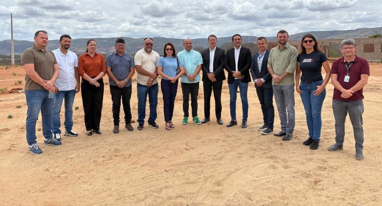 #PraTodosVerem: Na fotografia aparecem várias pessoas perfiladas em um terreno arenoso.