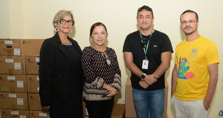 Justiça Eleitoral da Paraíba doa equipamentos de informática para o IFPB #PraTodosVerem: Na fotografia aparecem duas mulheres e dois homens, em pé, posando; atrás deles ...