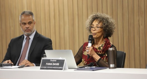 Justiça Restaurativa reúne palestrantes renomados na Paraíba_fania Foto 1: #PraTodosVerem: Na fotografia aparece uma mulher falando ao microfone em uma mesa de deb...