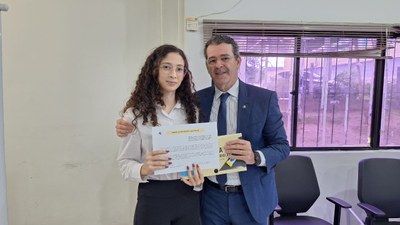 #PraTodosVerem: Na fotografia aparecem uma mulher e um homem, em pé, posando; ambos seguram um d...