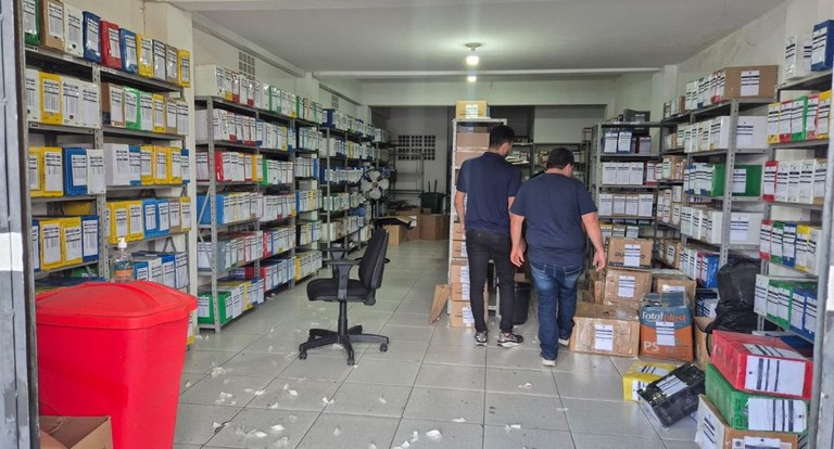 #PraTodosVerem: Na fotografia interna aparece uma sala com várias estantes contendo caixa de doc...