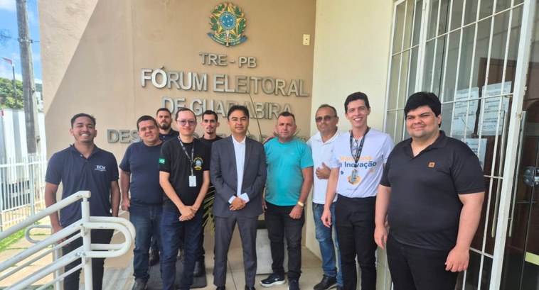 Na fotografia aparecem vários homens sorrindo para a foto, em frente ao Fórum Eleitoral de Guara...