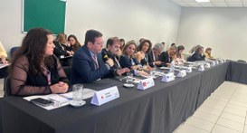 #PraTodosVerem: Na fotografia aparecem várias pessoas sentadas em uma mesa no formato de L, vest...