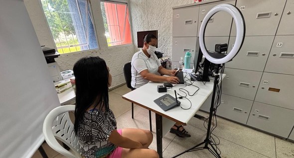 Foto 1: #PraTodosVerem: Na fotografia aparece uma servidora operando um computador em uma sala c...