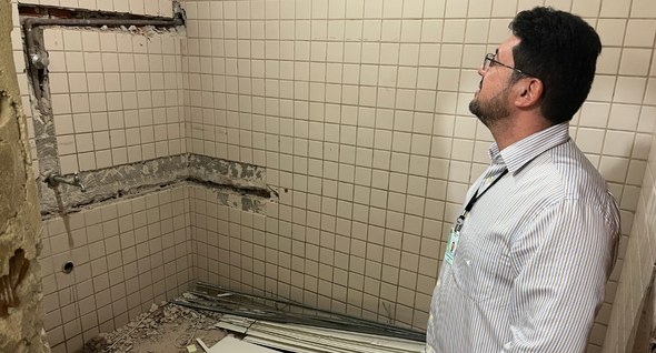 #PraTodosVerem: Na fotografia aparece um homem em uma sala em reforma com escombros.