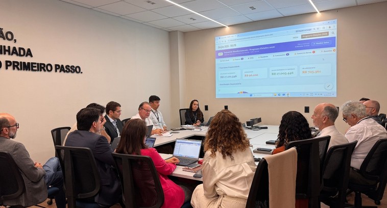 Painel de monitoramento reforça governança das Eleições 2026 no TRE-PB_capa #PraTodosVerem: Na fotografia aparece um grupo de pessoas em uma reunião de trabalho ao redor de...