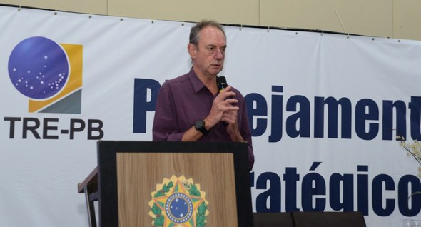 #PraTodosVerem: Na fotografia aparece um homem em cima de um palco proferindo uma palestra.
