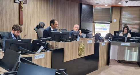 #PraTodosVerem: Na fotografia aparecem várias pessoas sorrindo para a foto, em uma sala de sessão