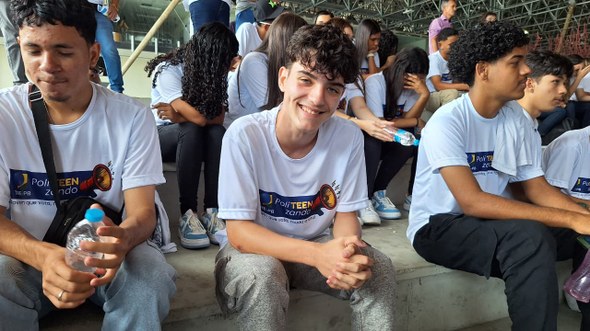 #PraTodosVerem: Na fotografia aparece um jovem, sorrindo para a câmera. Ele está sentado em uma ...