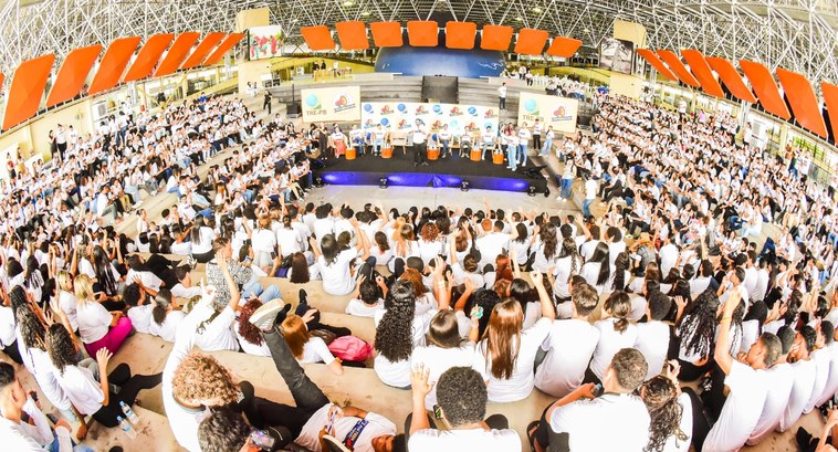 #PraTodosVerem: Na fotografia aparece uma multidão de jovens, vestindo camisetas brancas, sentad...