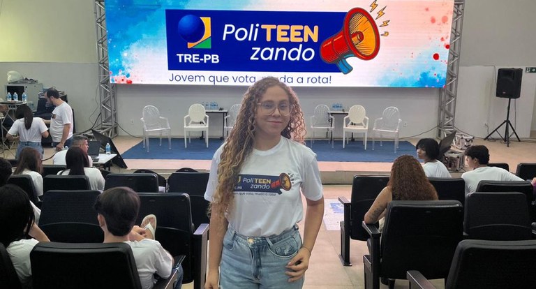 Foto 3: #PraTodosVerem: Na fotografia aparece uma jovem de cabelos cacheados e óculos, vestindo ...