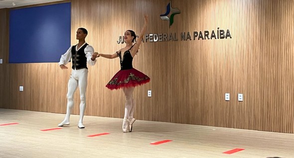 popruajud_bale Foto_bale: #PraTodosVerem: Na fotografia aparece um casal de bailarinos no palco, com o fundo em...