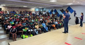 Capa: #PraTodosVerem: Na fotografia aparece a plateia de um auditório. Em primeiro plano, no pal...