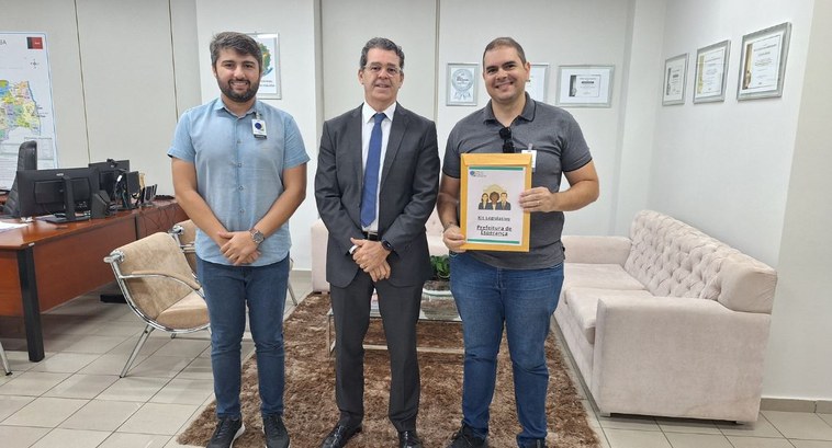 Prefeitura de Esperança vai implantar gratificação a requisitados do TRE-PB_CAPA #PraTodosVerem: Na fotografia aparecem três homens sorrindo para a foto, em uma sala de reunião....
