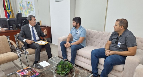 #PraTodosVerem: Na fotografia interna aparecem três homens sentados, dialogando em uma sala de r...