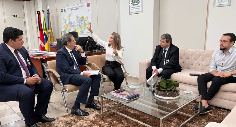 Prefeitura do Conde implanta lei de valorização dos servidores requisitados pelo TRE-PB #PraTodosVerem: Na fotografia aparece um grupo de pessoas sentadas em sofás em torno de uma mesa...