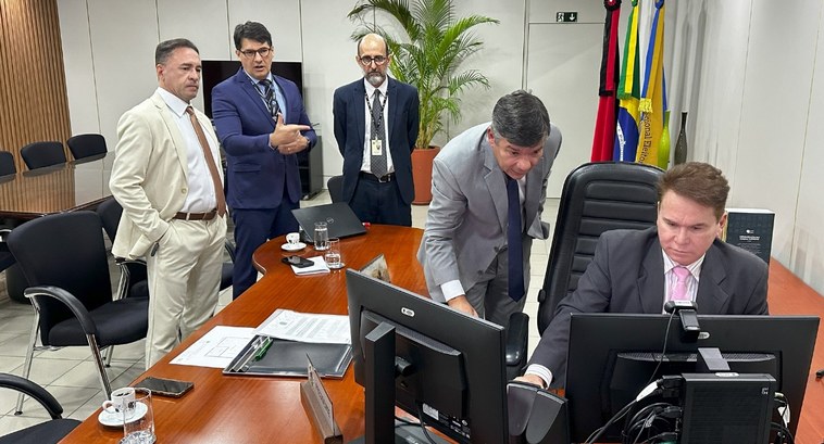 #PraTodosVerem: Na fotografia aparece um homem de terno escuro e gravata rosa sentado diante de ...